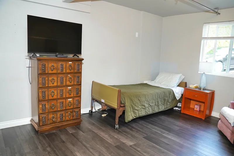 A resident bedroom with a television and an adjustable bed