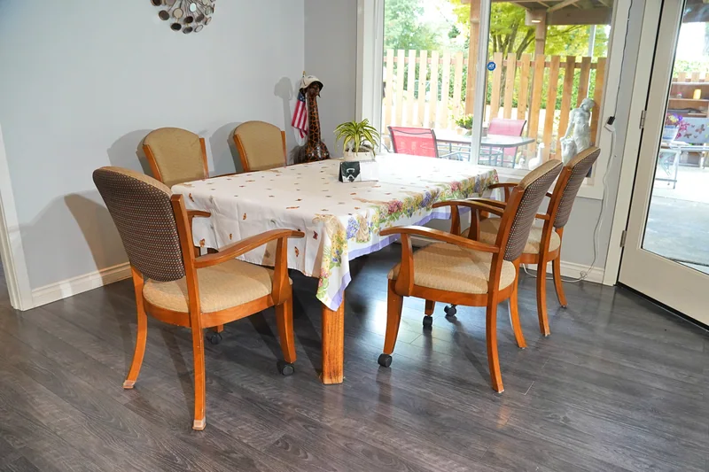 The dining table set with chairs beside the garden doors