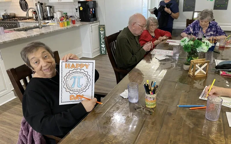 Stock image: residents gathered around a table for an activity