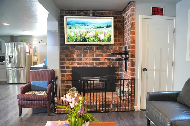 Seating gathered around the fireplace in the living room at Bear Care AFH II