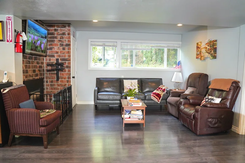 The living room at Bear Care AFH II with sofas and a brick fireplace