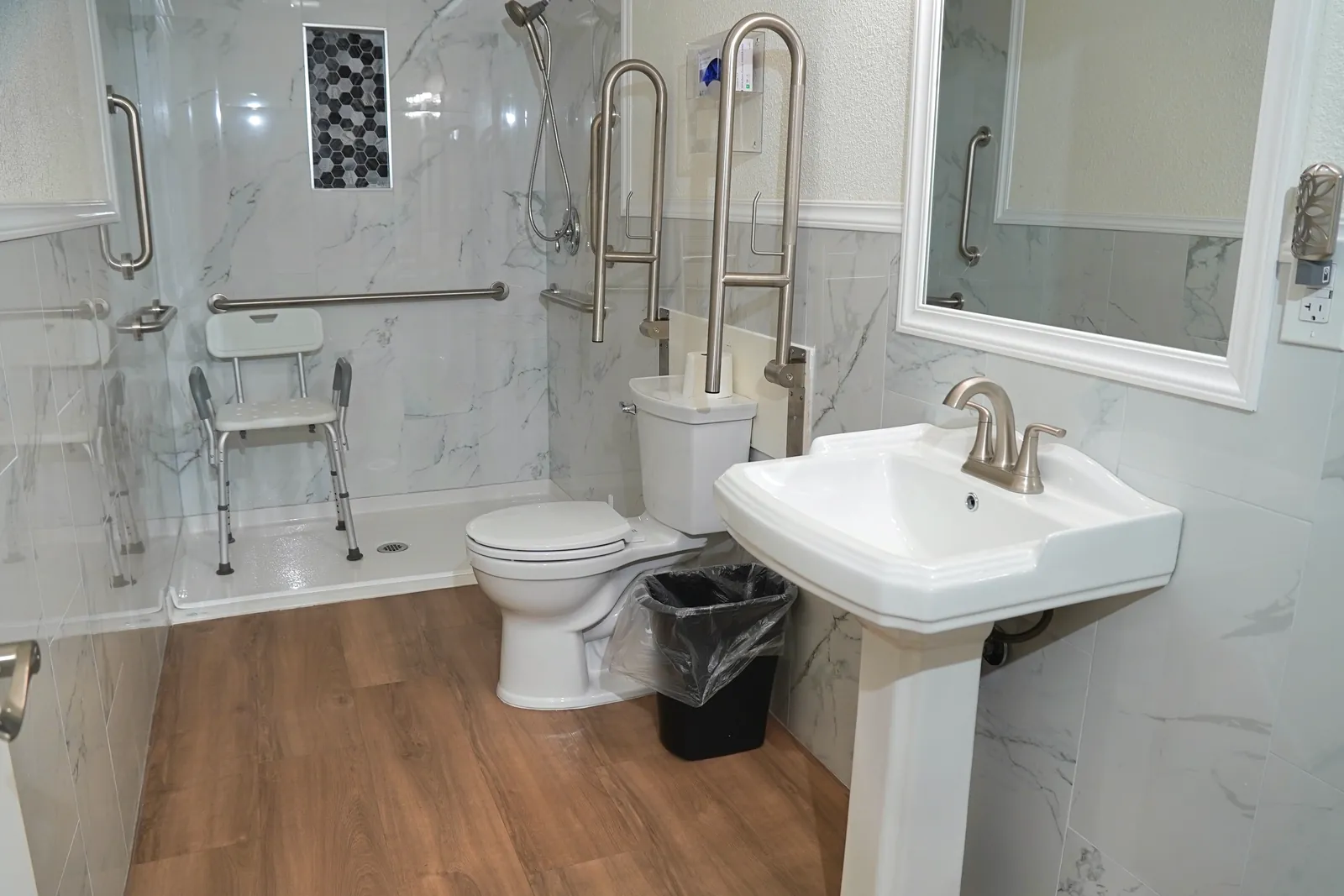 Accessible bathroom with a shower seat, grab bars and a basin