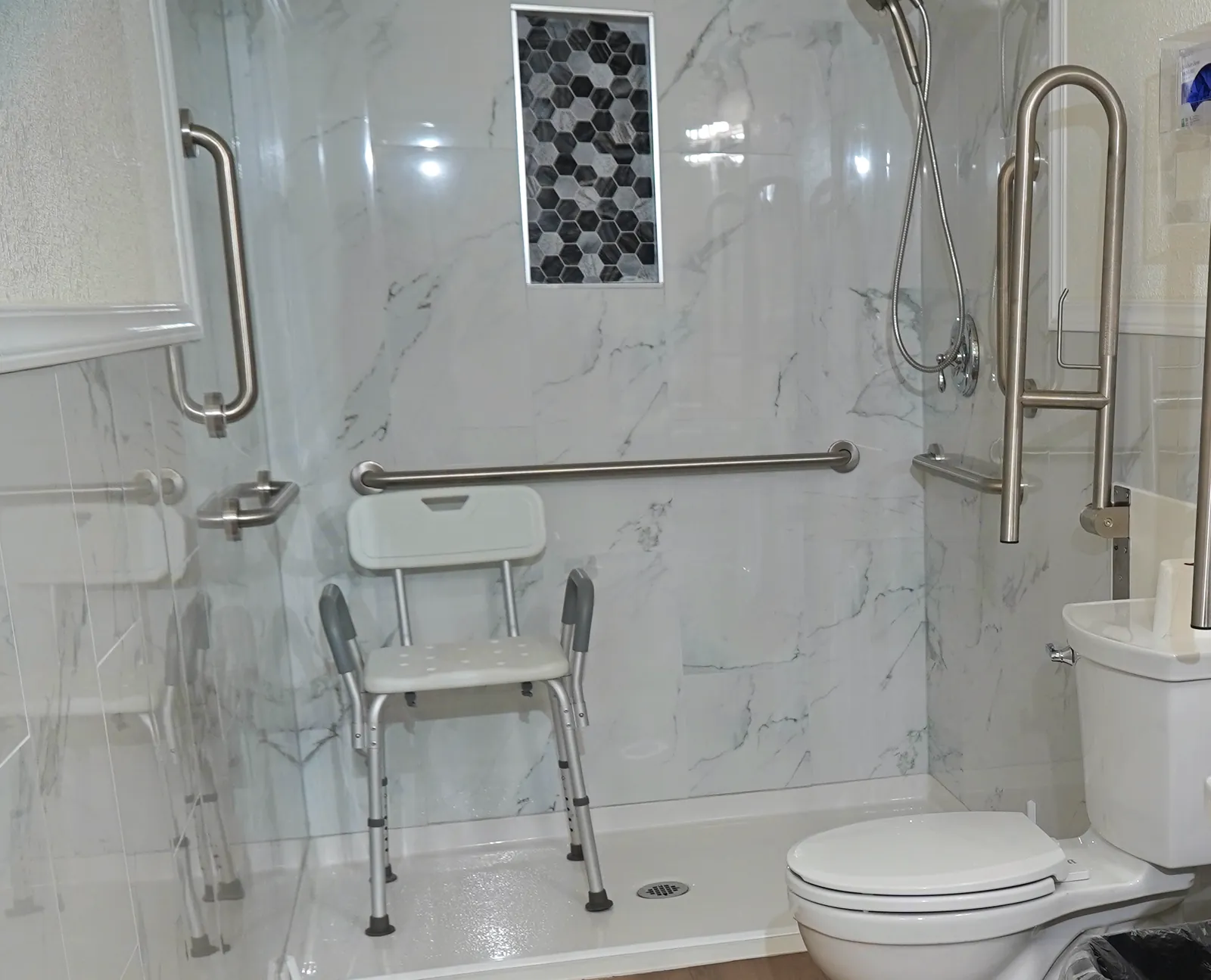 Roll-in shower with grab bars and a hand-held shower head
