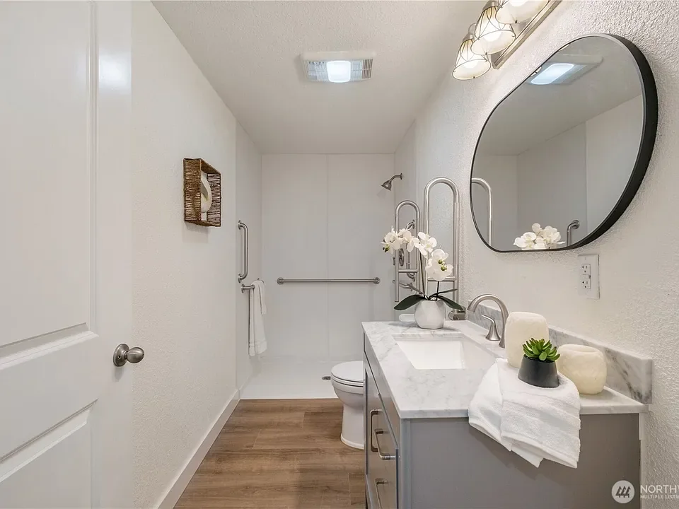Bathroom with a wide vanity, mirror and a step-free shower