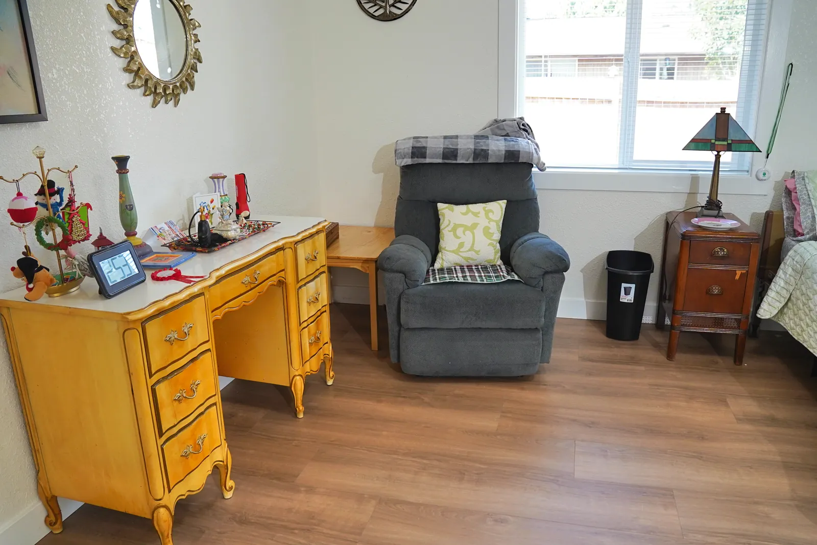 Bedroom with a writing desk, armchair and personal keepsakes
