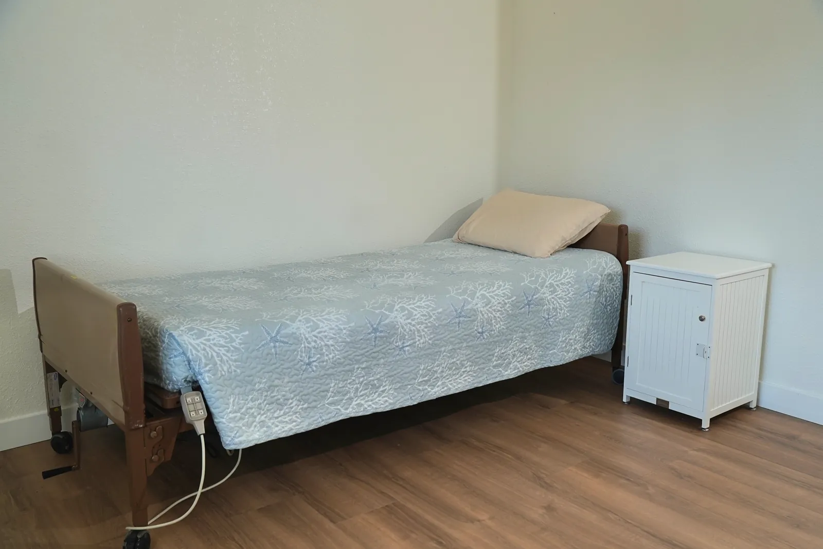 Bedroom with an adjustable single bed and a bedside cabinet