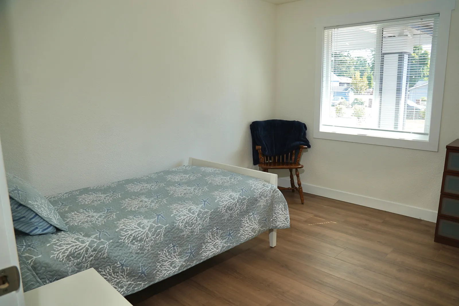 Bedroom with a single bed beside a bright window