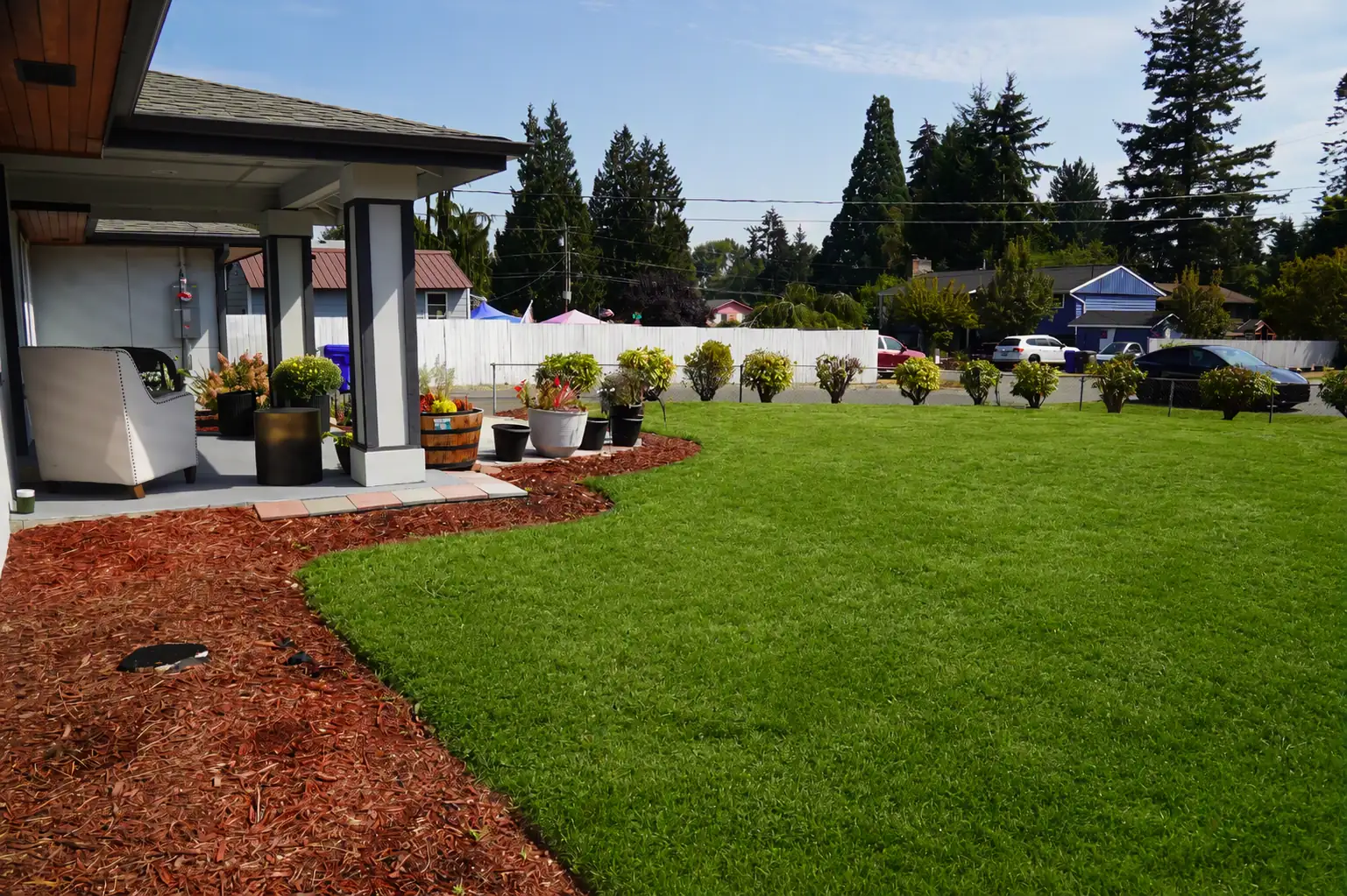 Patio and bark border opening onto a large back lawn