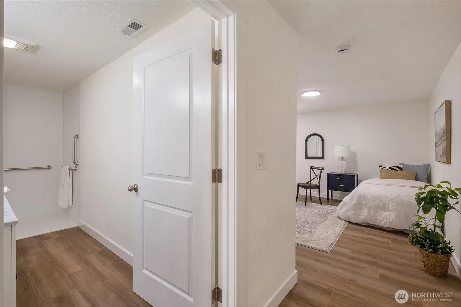 Hallway with a grab rail leading through to a bedroom