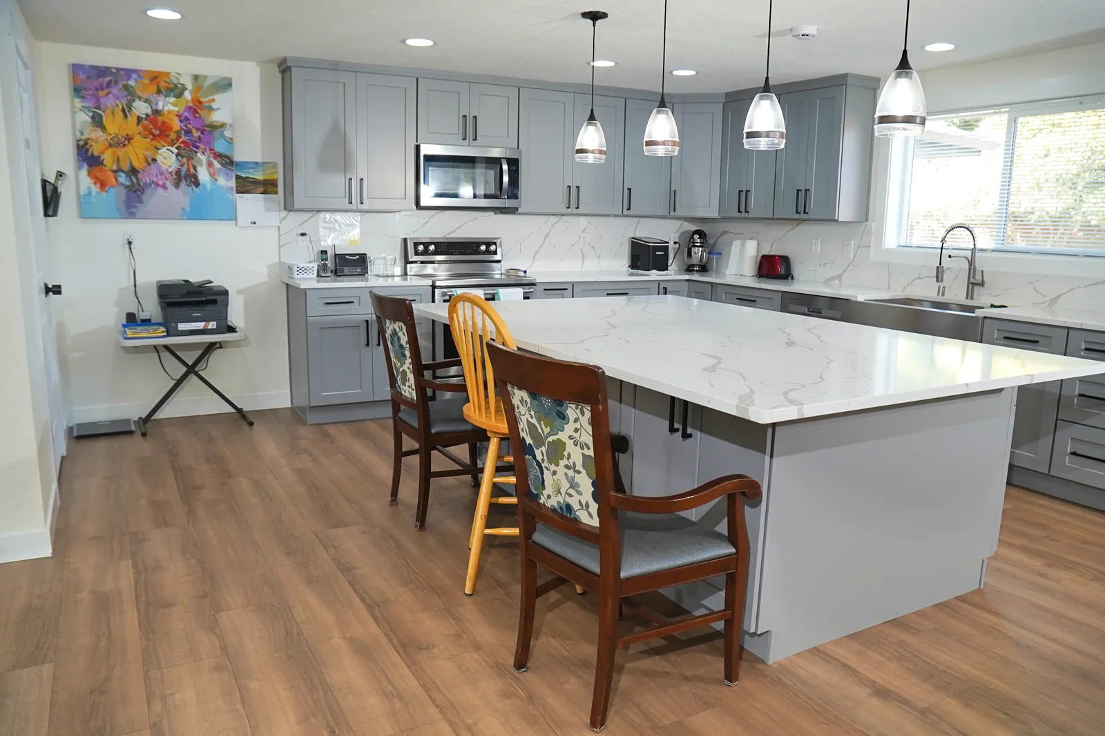 Kitchen with a stone island, pendant lights and seating