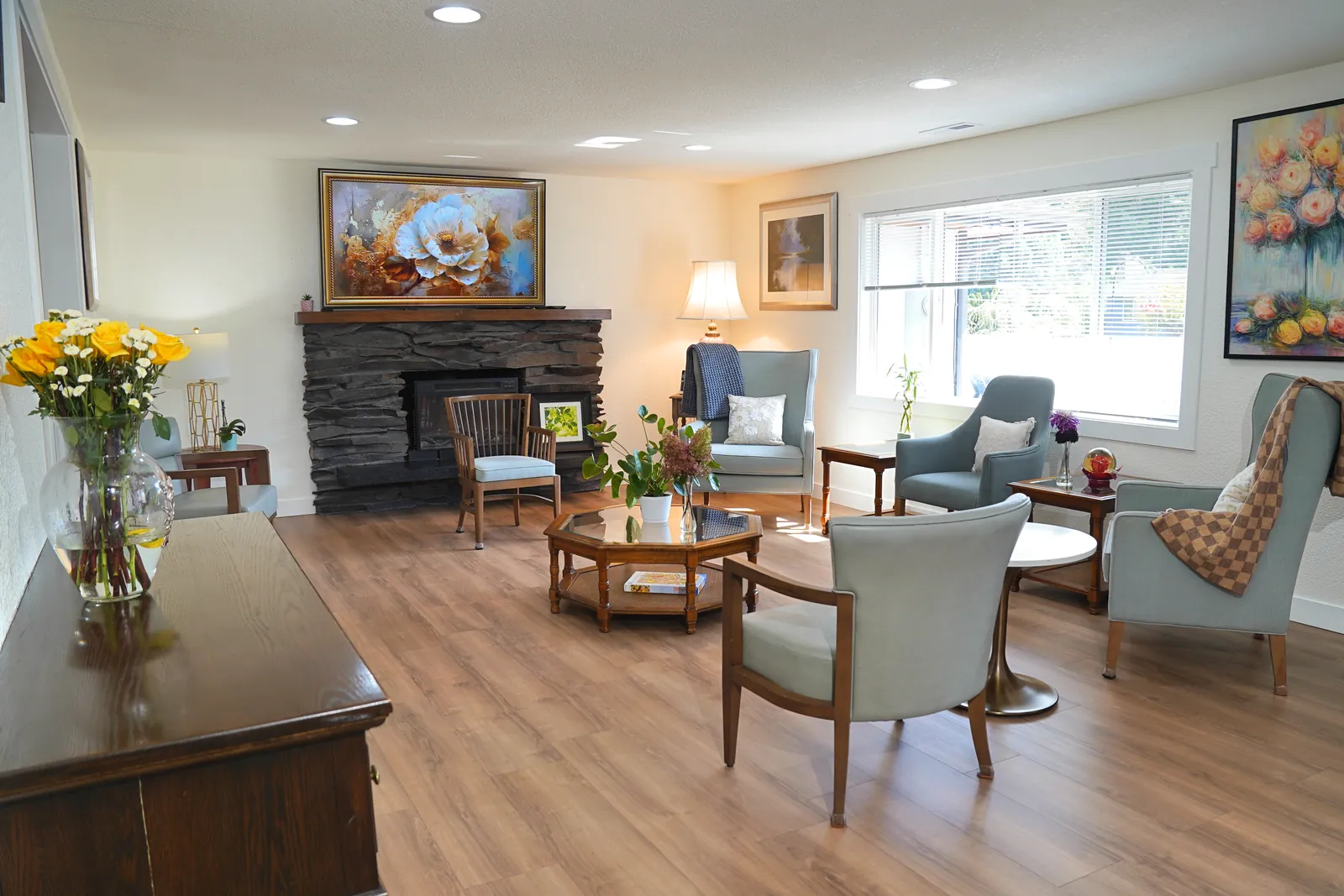 Living room with a stone fireplace, armchairs and a low table