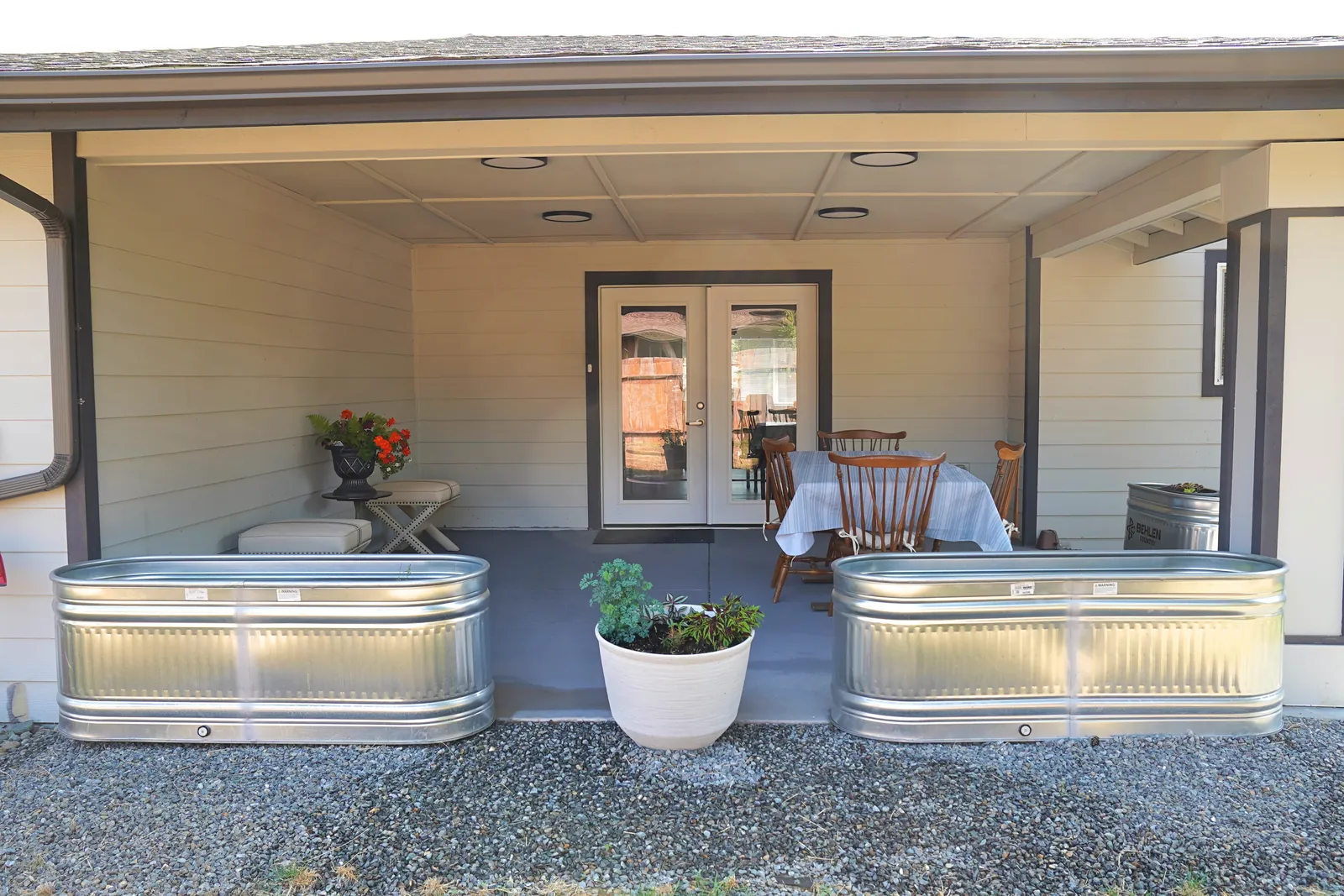 Covered patio with french doors, planters and raised beds