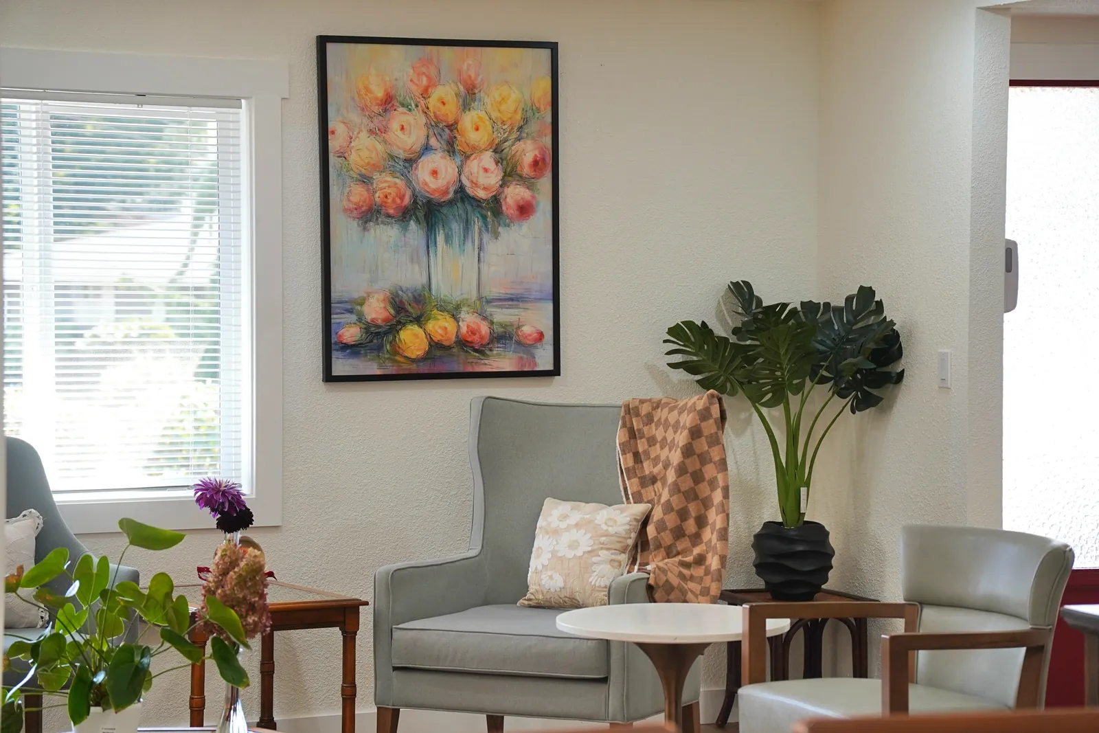 Quiet corner with an armchair, side table and plants by a window
